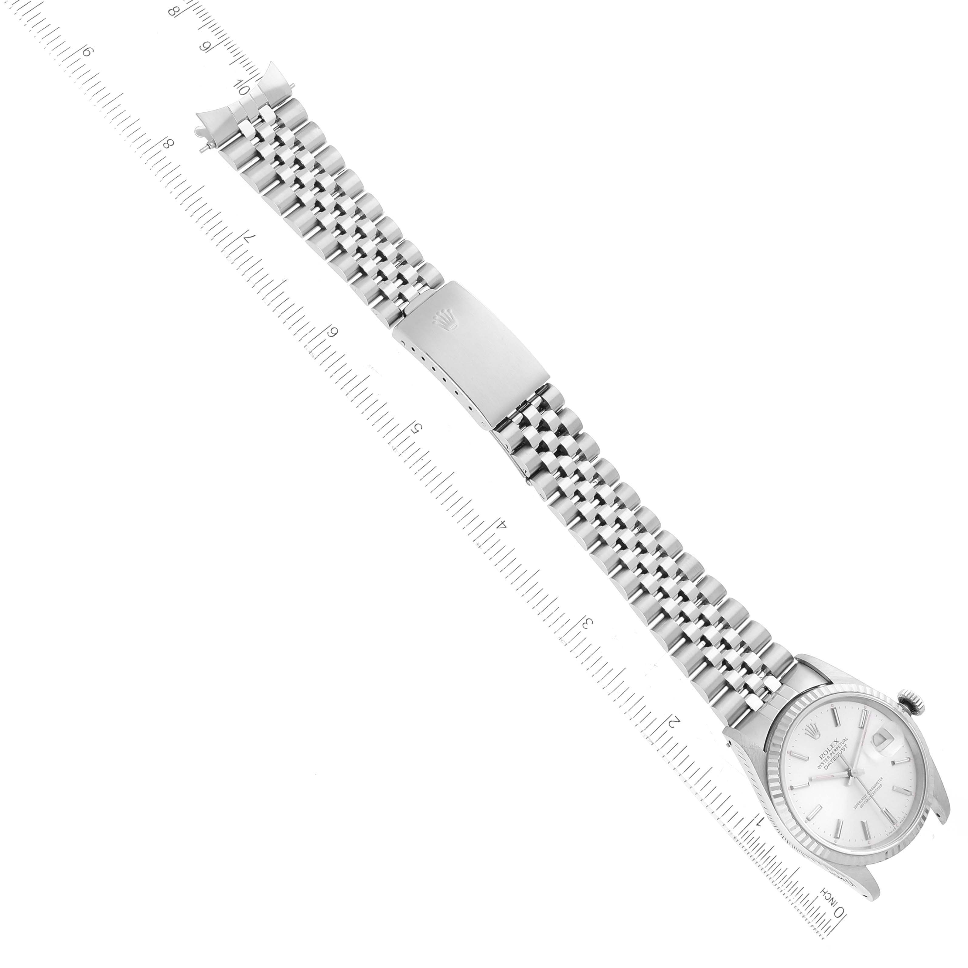 This image shows a top-down view of a Rolex Datejust 16234 Men's Stainless Steel Silver Dial 16234 Men's Stainless Steel Silver Dial watch, displaying its face, bracelet, and clasp, alongside a measuring scale.