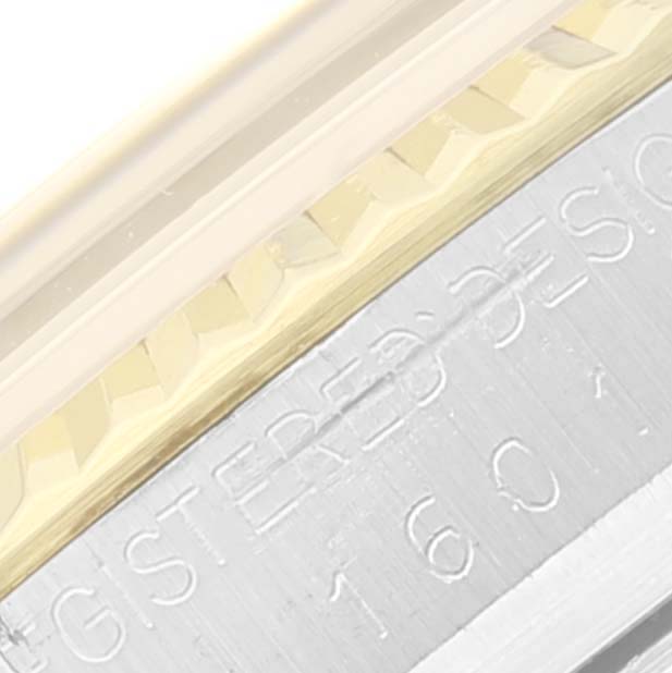 Close-up of the bezel and case side of the Rolex Vintage Collection 1601 Men's Steel and Gold (two tone) Champagne Dial 1601 Men's Steel and Gold (two tone) Champagne Dial watch, showing part of the engraved text and fluted edge.