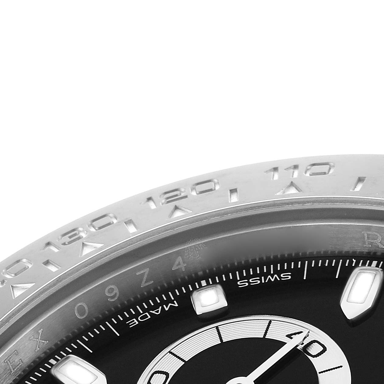 The image shows a close-up of the bezel and part of the dial of a Rolex Daytona 116500 Men
s Stainless Steel Black Dial watch, highlighting the tachymetric scale.