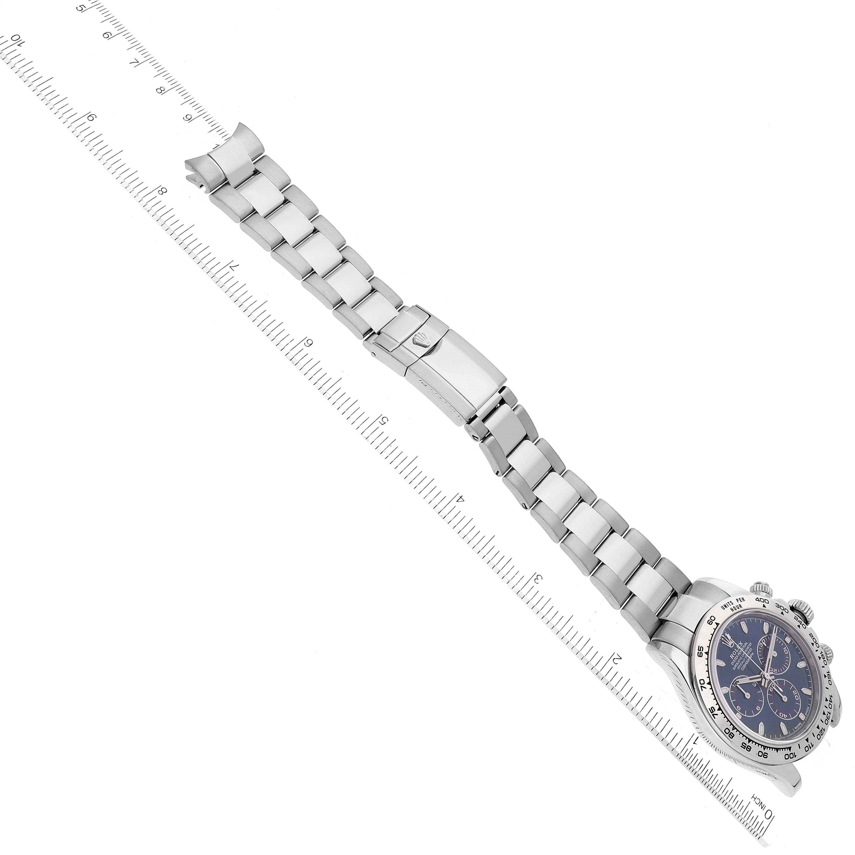 The image shows a Rolex Daytona 116509 Men's White Gold Blue Dial 116509 Men's White Gold Blue Dial watch laid flat, showcasing its bracelet, clasp, and partially the face, alongside a measuring ruler.