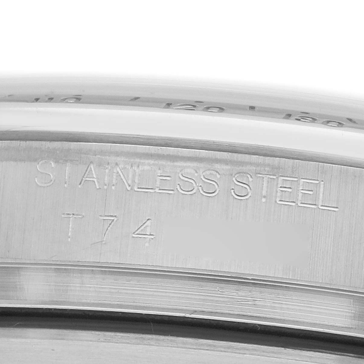 The image shows a close-up of the engraved "Stainless Steel" marking on the side of a Rolex Daytona 16520 Men
s Stainless Steel Black Dial watch bezel.