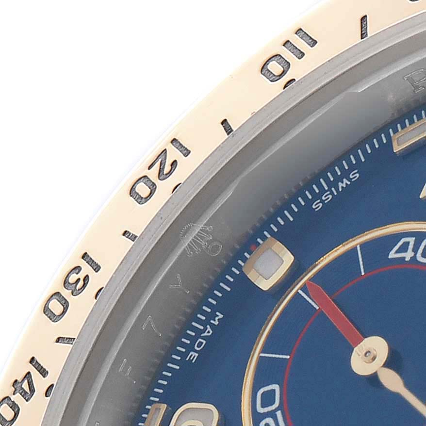 The image shows a close-up angle of the bezel and partial dial of a Rolex Daytona 116523 Men
s Steel and Gold (two tone) Blue Dial watch.