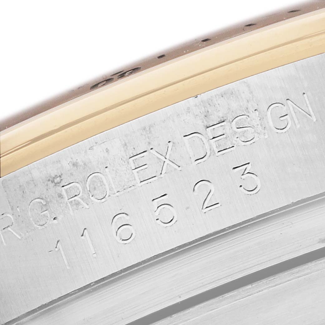 The image shows a close-up of the engraved side of a Rolex Daytona 116523 Men
s Steel and Gold (two tone) Blue Dial, highlighting the model number and "ROLEX DESIGN" text.