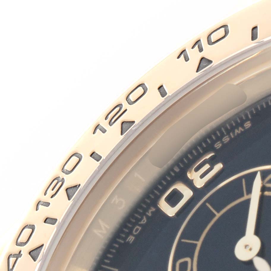The image shows a close-up of the bezel and part of the dial of a Rolex Daytona 116518 Men
s Yellow Gold Black Dial, focusing on the tachymeter scale.