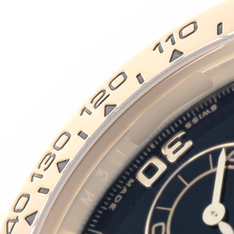 The image shows a close-up of the bezel and part of the dial of the Rolex Daytona 116518 Men's Yellow Gold Black Dial, highlighting the tachymetric scale and numerals.