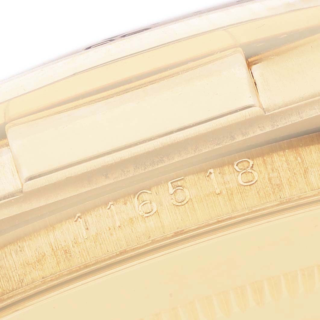 The image shows a close-up of the case side and part of the bezel with engraved numbers on a Rolex Daytona 116518 Men
s Yellow Gold Black Dial watch.