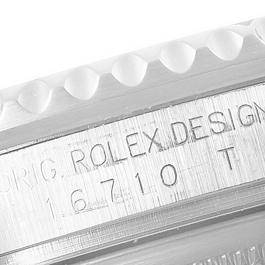 This image shows an etched part of a Rolex GMT-Master 16710 Men
s Stainless Steel Black Dial 16710 Men
s Stainless Steel Black Dial watch case near the bezel, displaying model number 16710.