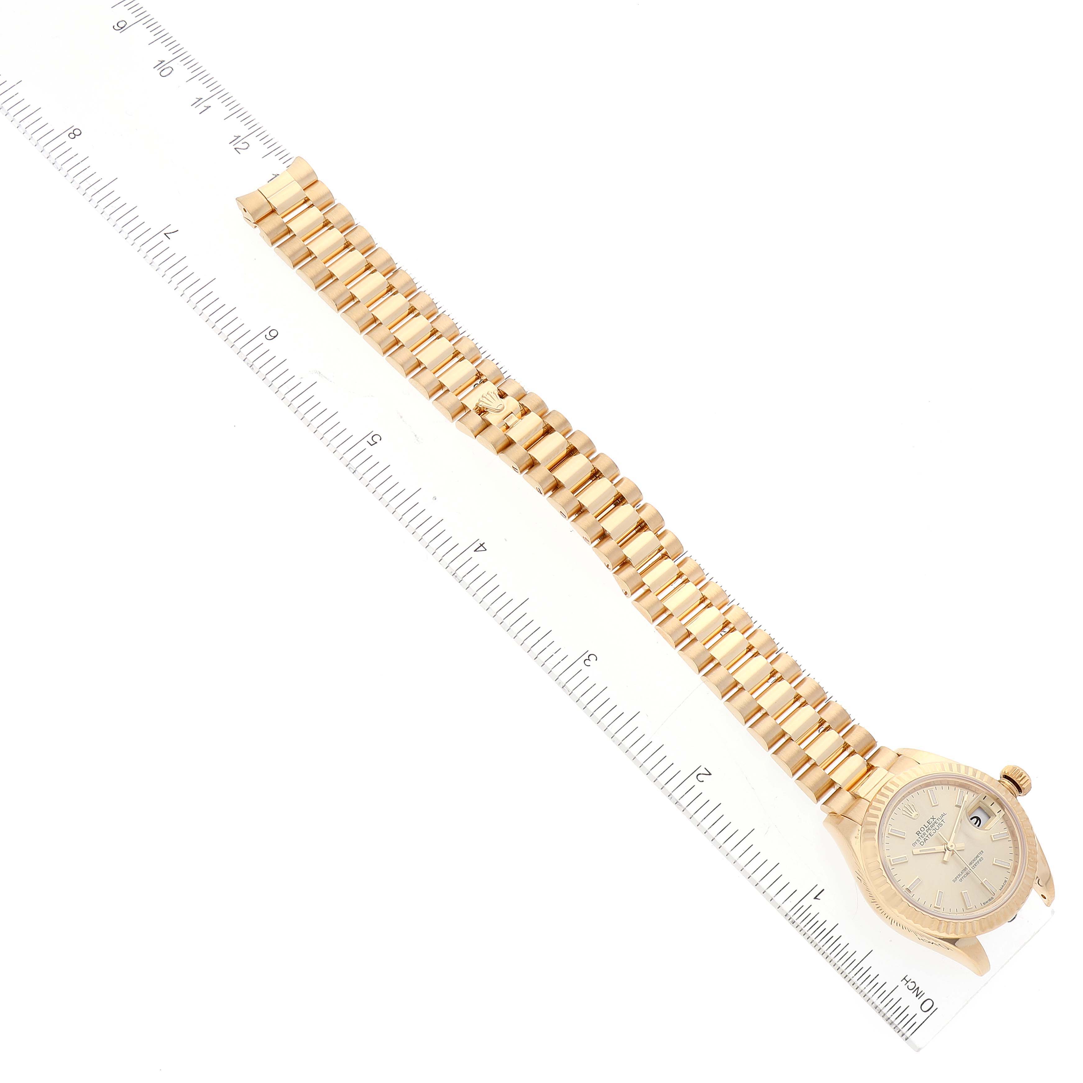The image shows a Rolex President 279178 Women's Yellow Gold Champagne Dial 279178 Women's Yellow Gold Champagne Dial model watch laid flat, with focus on its bracelet, case, and dial, and accompanied by a ruler for scale.