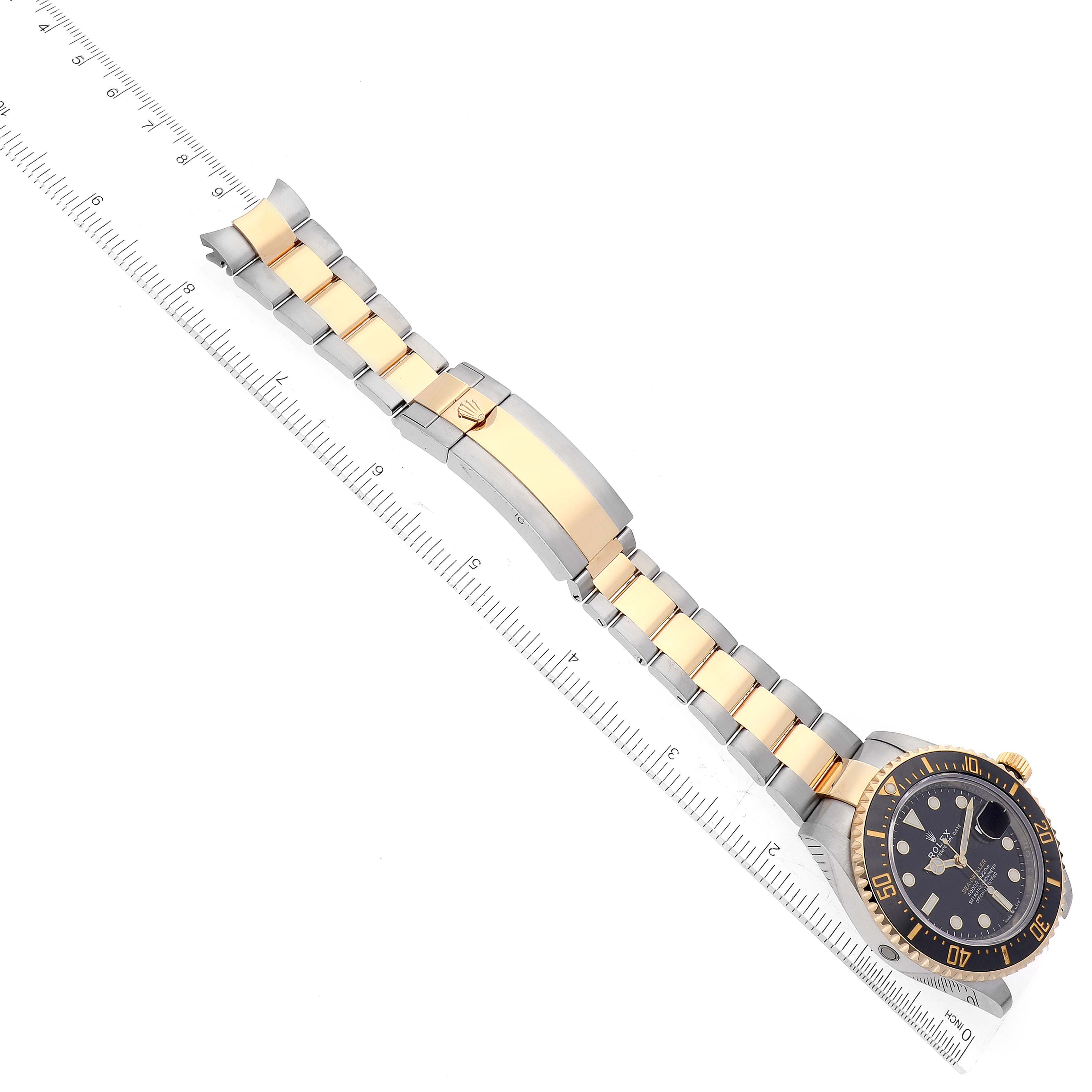 The image shows a top-down angle of a Rolex Sea-Dweller 126603 Men
s Steel and Gold (two tone) Black Dial 126603 Men
s Steel and Gold (two tone) Black Dial watch, including its two-tone metal bracelet and clasp.