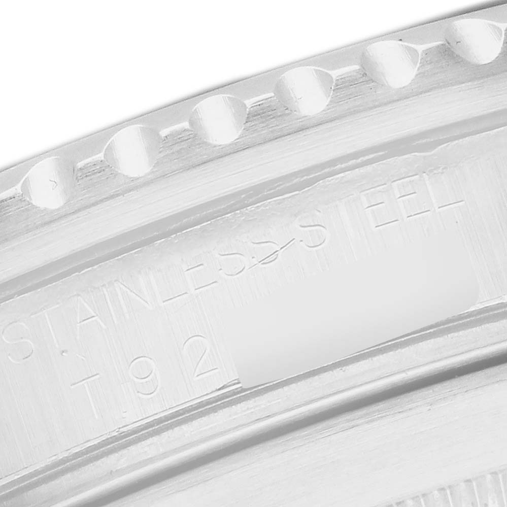 The image shows a close-up of the engraved inner bezel of a Rolex Submariner 16610 Men
s Stainless Steel Black Dial, highlighting the "STAINLESS STEEL" text.