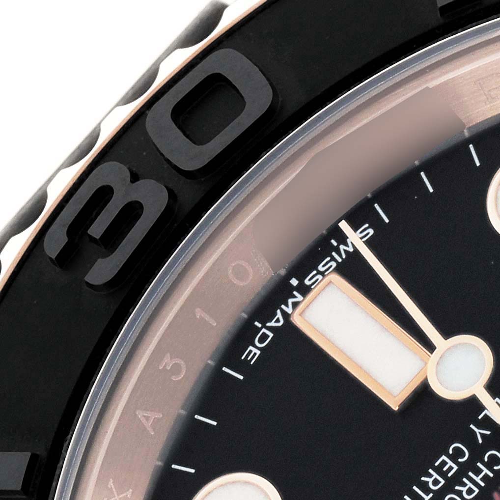 The image shows a close-up of the bezel and dial of the Rolex Yacht-Master 116655 Men
s Rose Gold Black Dial watch, highlighting the numerals and part of the hands.