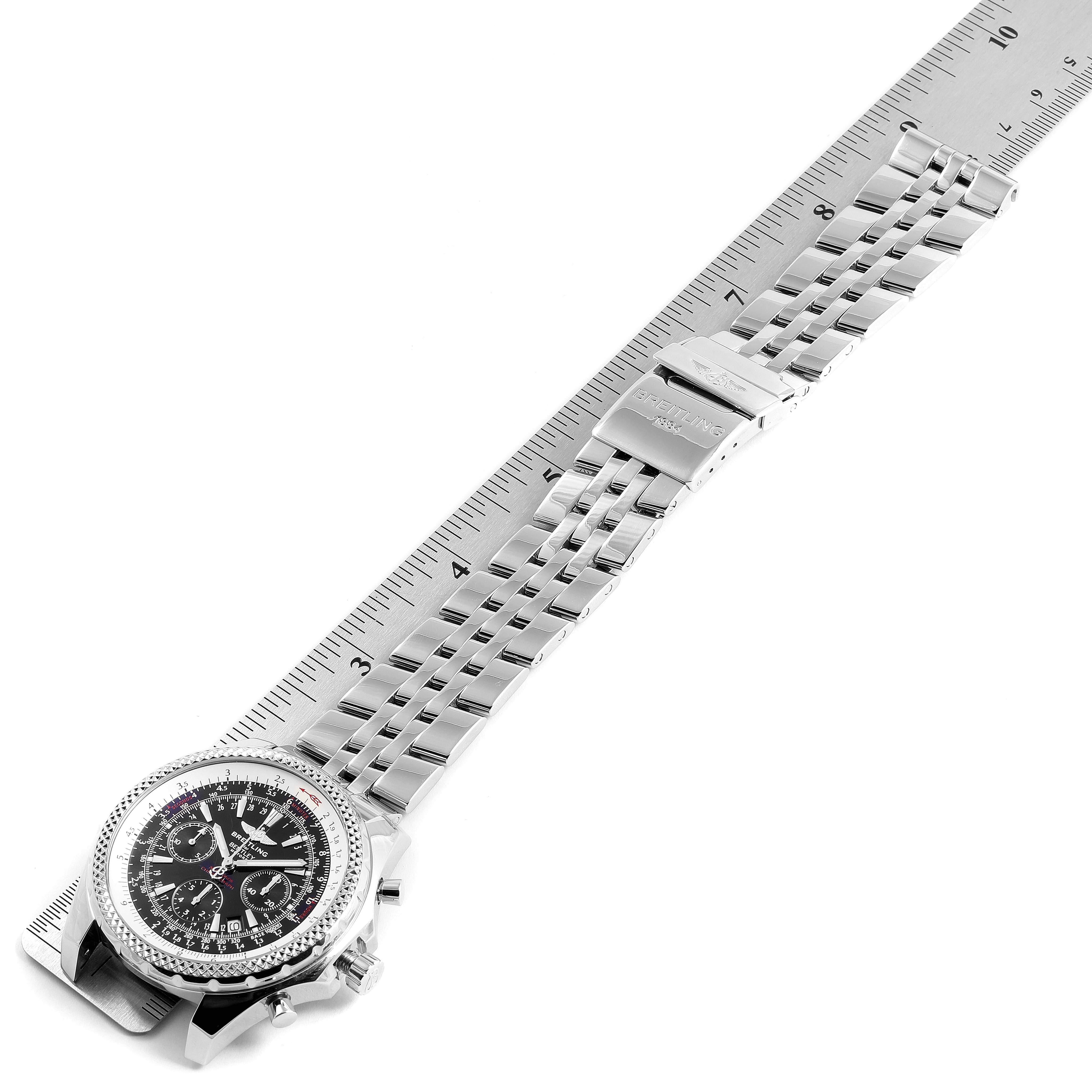 The Breitling Bentley A25362 Men's Stainless Steel Black Dial A25362 Men's Stainless Steel Black Dial watch is shown from an angled top view, displaying the face, bezel, and metal bracelet alongside a ruler.