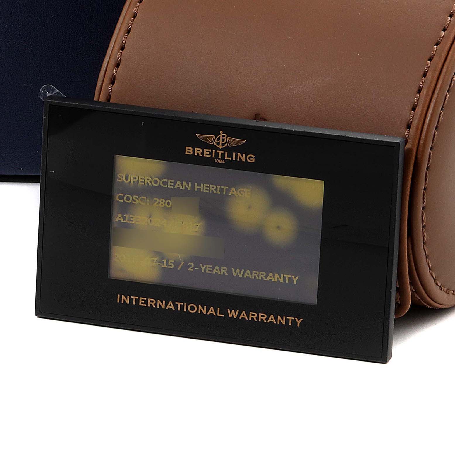 This image shows the international warranty card for the Breitling Superocean A13320 Men's Stainless Steel Blue Dial A13320 Men's Stainless Steel Blue Dial model, along with a brown leather watch case.