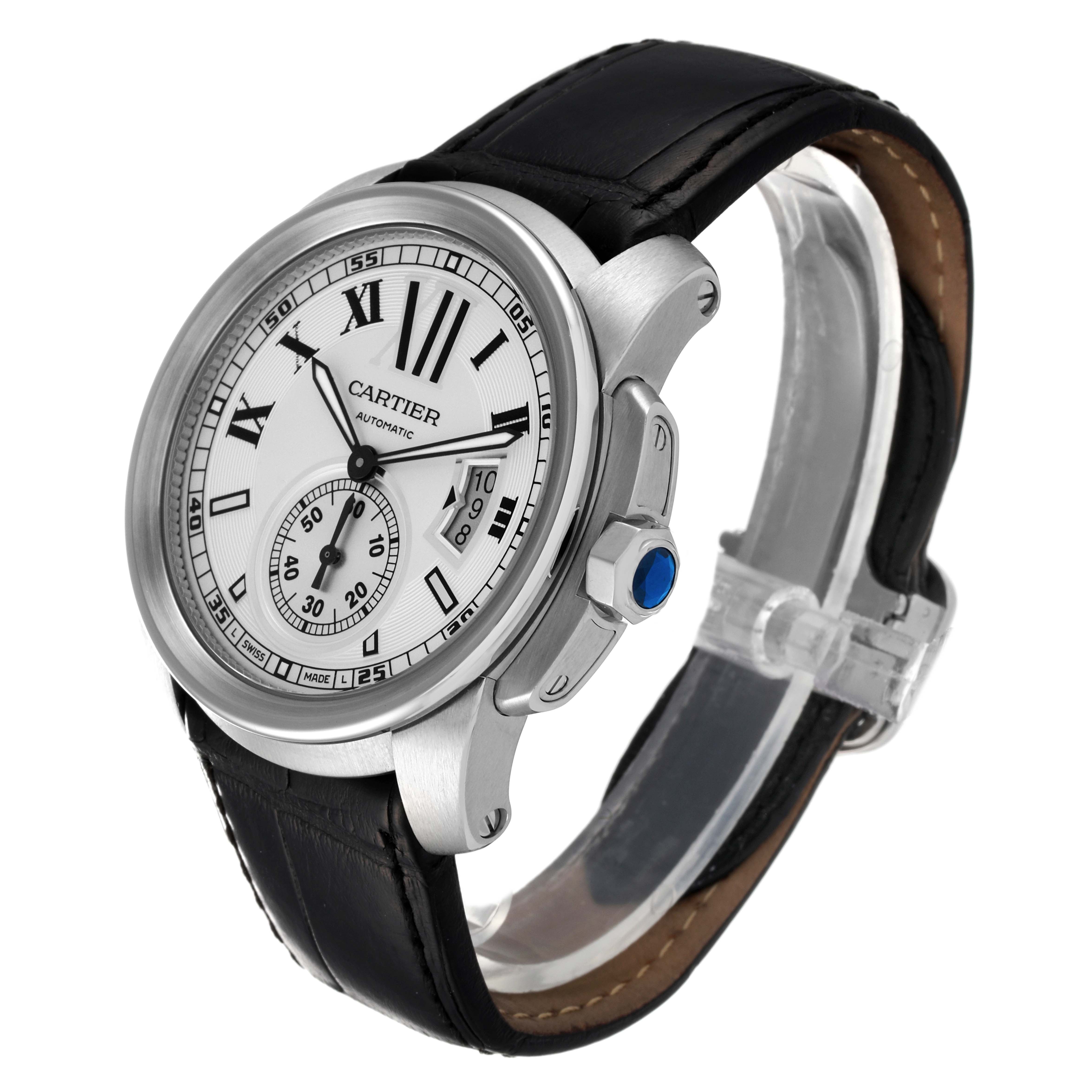 This image shows a Calibre de Cartier watch by Cartier from a three-quarter angle with a focus on the watch face, crown, and leather strap.