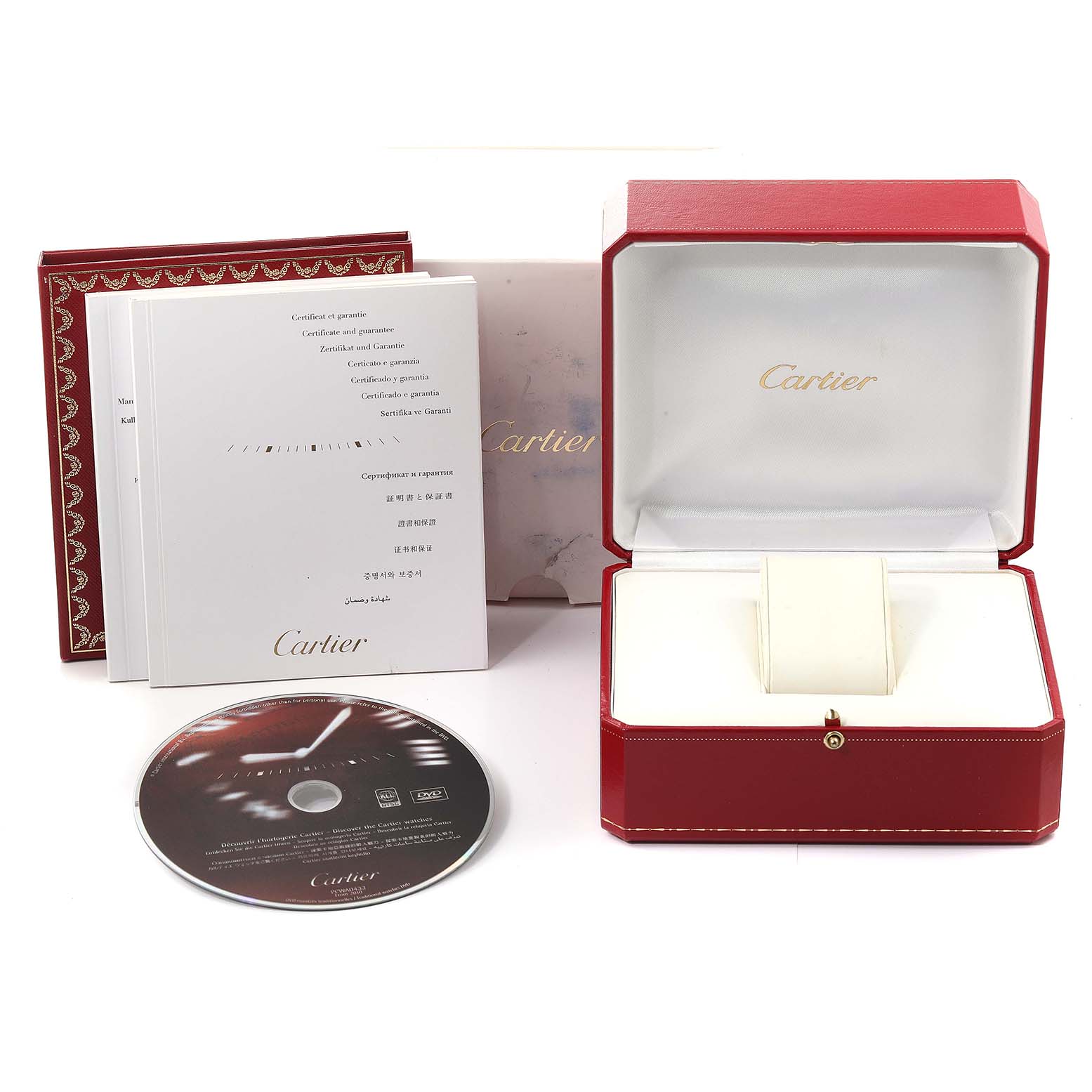 The image shows a Calibre de Cartier watch box set including an empty watch case, manuals, and a promotional CD, all branded by Cartier.