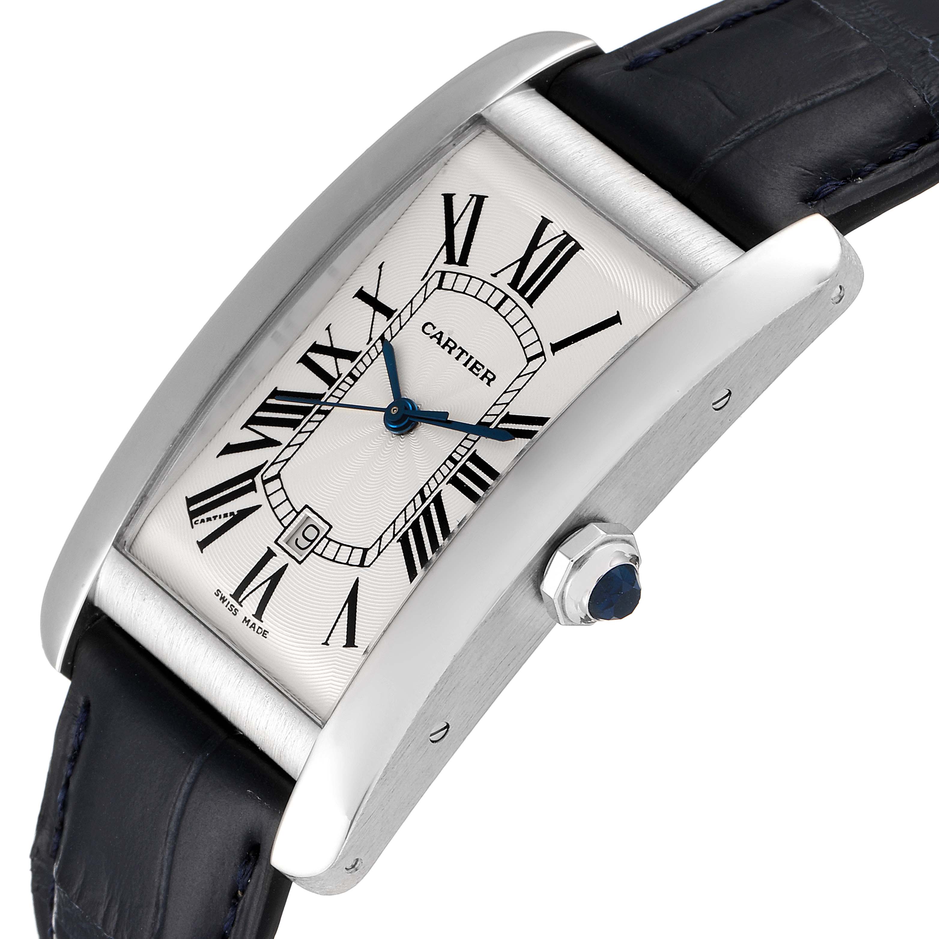 The image shows a Cartier Tank Americaine W2603256 Men's White Gold Silver Dial W2603256 Men's White Gold Silver Dial watch, highlighting its face, crown, and black leather band from an angled perspective.