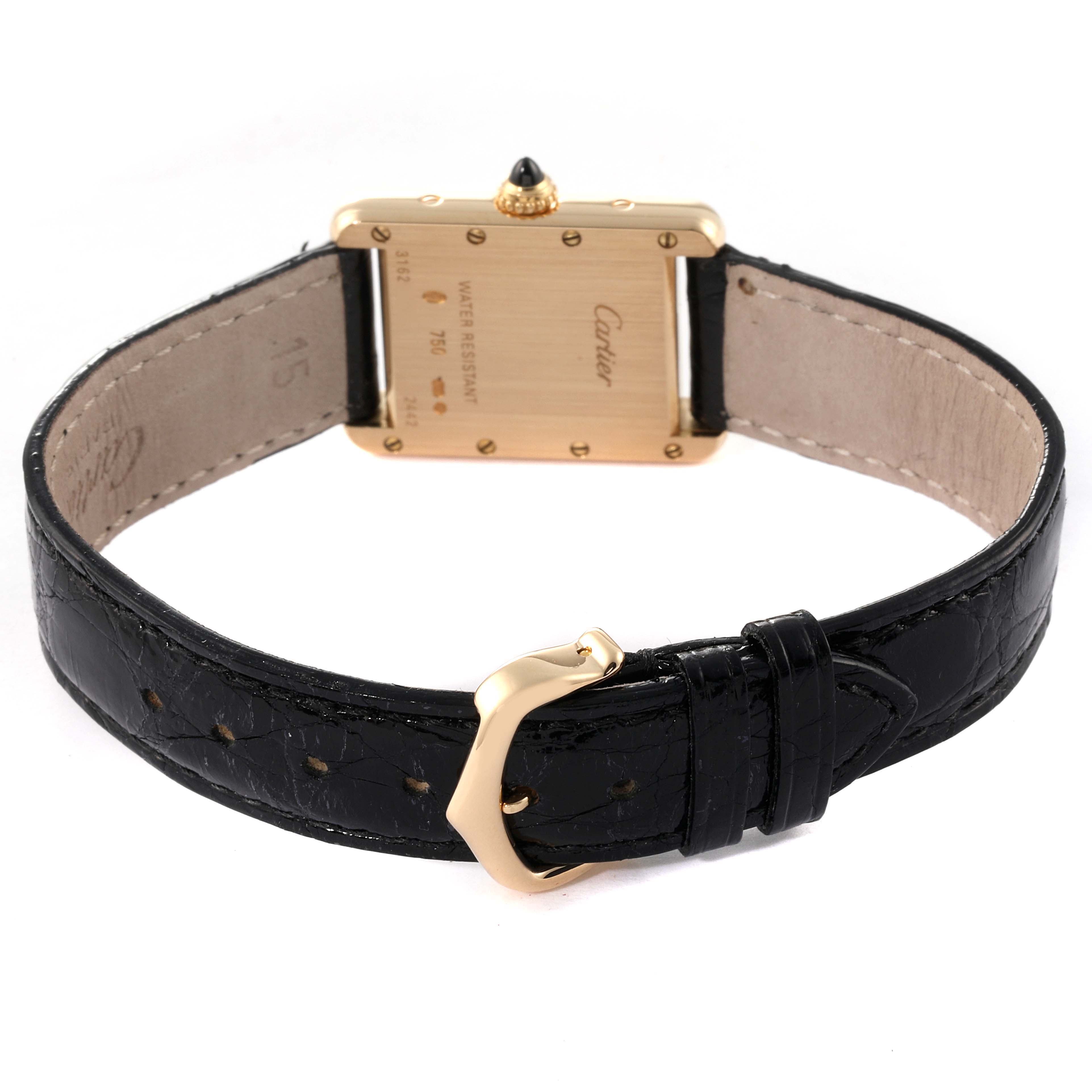 The image shows the back of a Tank Louis model watch by Cartier, with a black leather strap and a gold buckle.