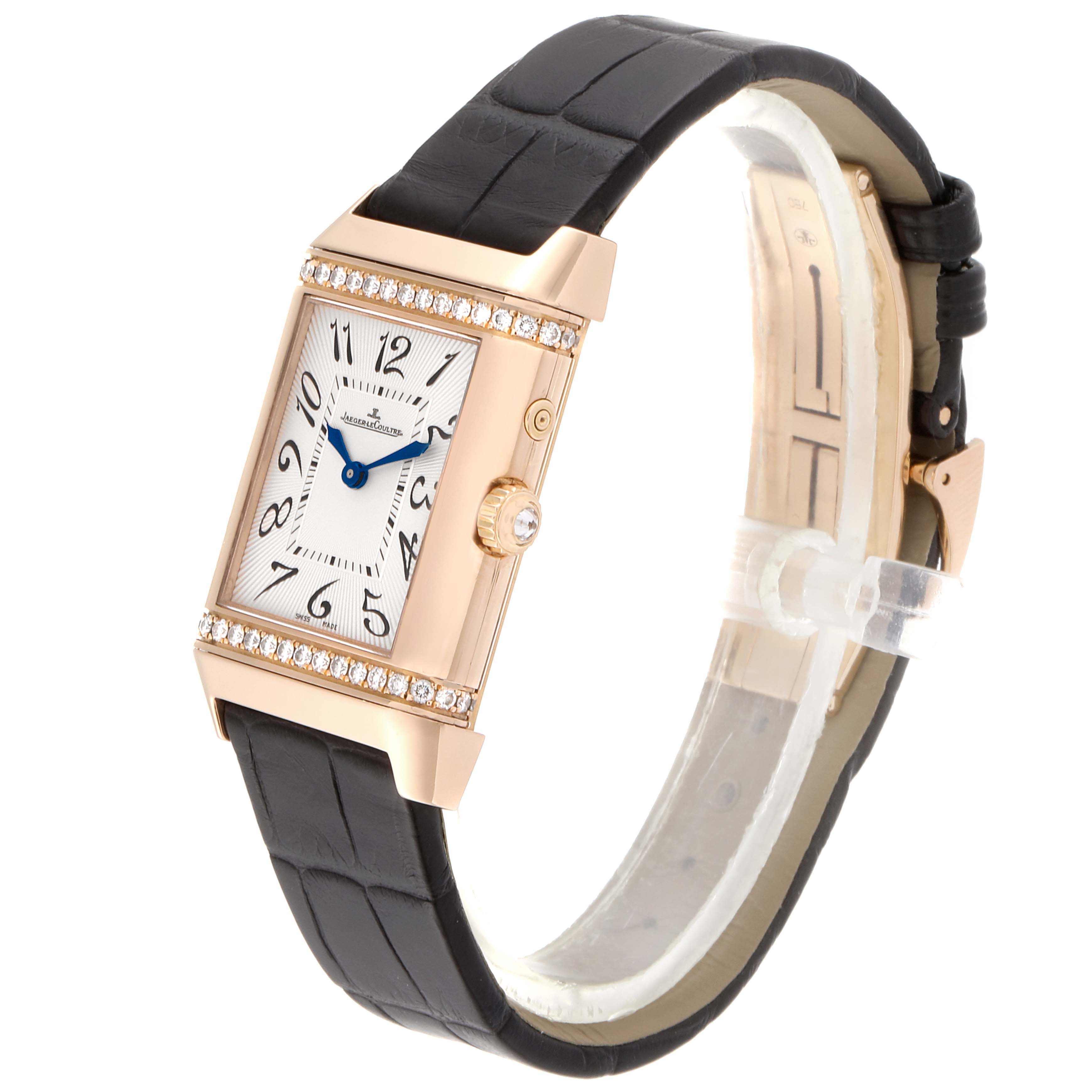 This image shows a Jaeger-LeCoultre Reverso watch at a three-quarter angle, highlighting its rectangular face, leather strap, and diamond bezel.