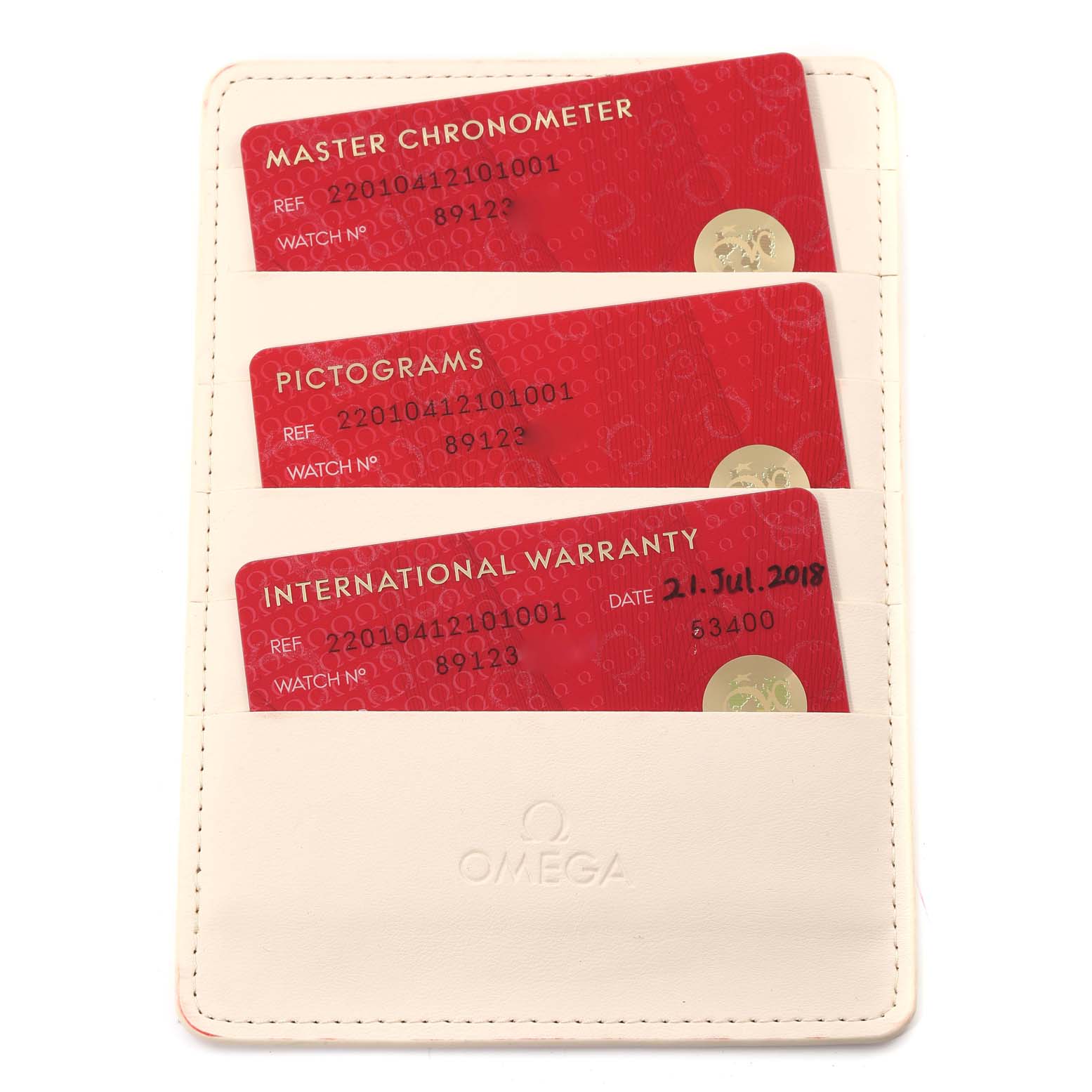 The image shows a white cardholder containing three red cards: Master Chronometer, Pictograms, and International Warranty for the Omega Aqua Terra 220.10.41.21.01.001 Men's Stainless Steel Black Dial 220.10.41.21.01.001 Men's Stainless Steel Black Dial model.