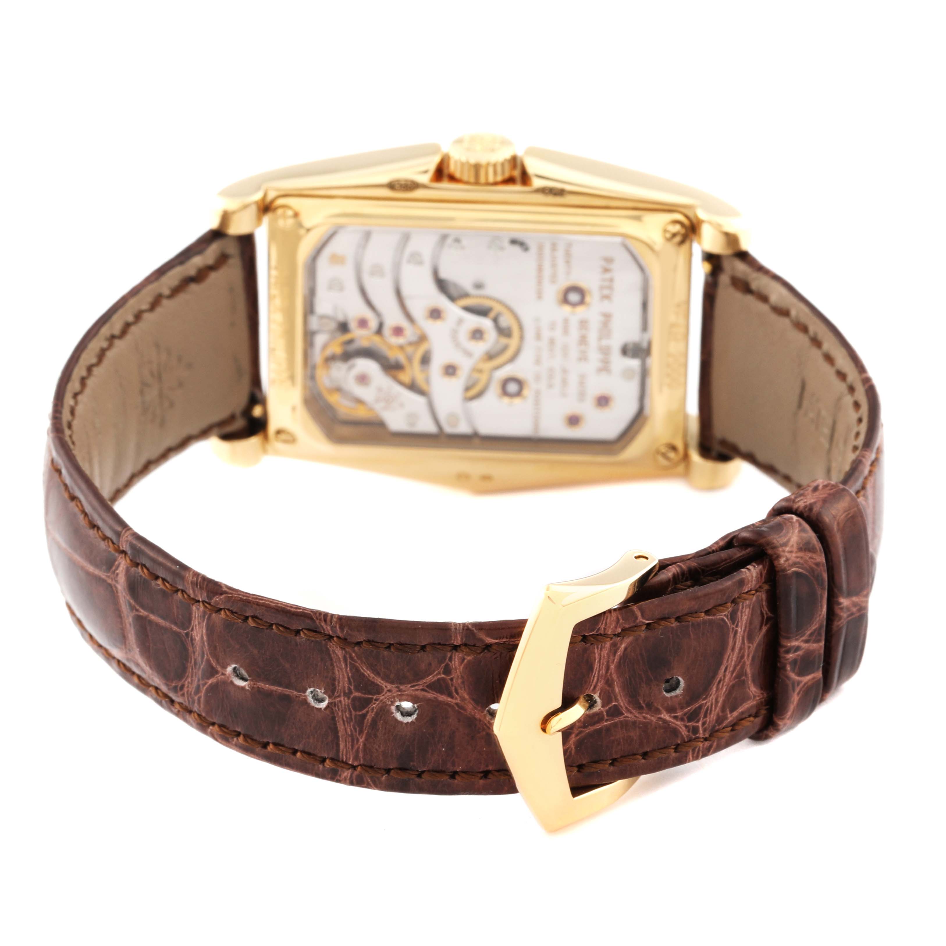 This image shows the back side of a Patek Philippe Gondolo 5100J -001 Men's Yellow Gold Silver Dial 5100J -001 Men's Yellow Gold Silver Dial watch displaying its mechanical movement and brown leather strap.