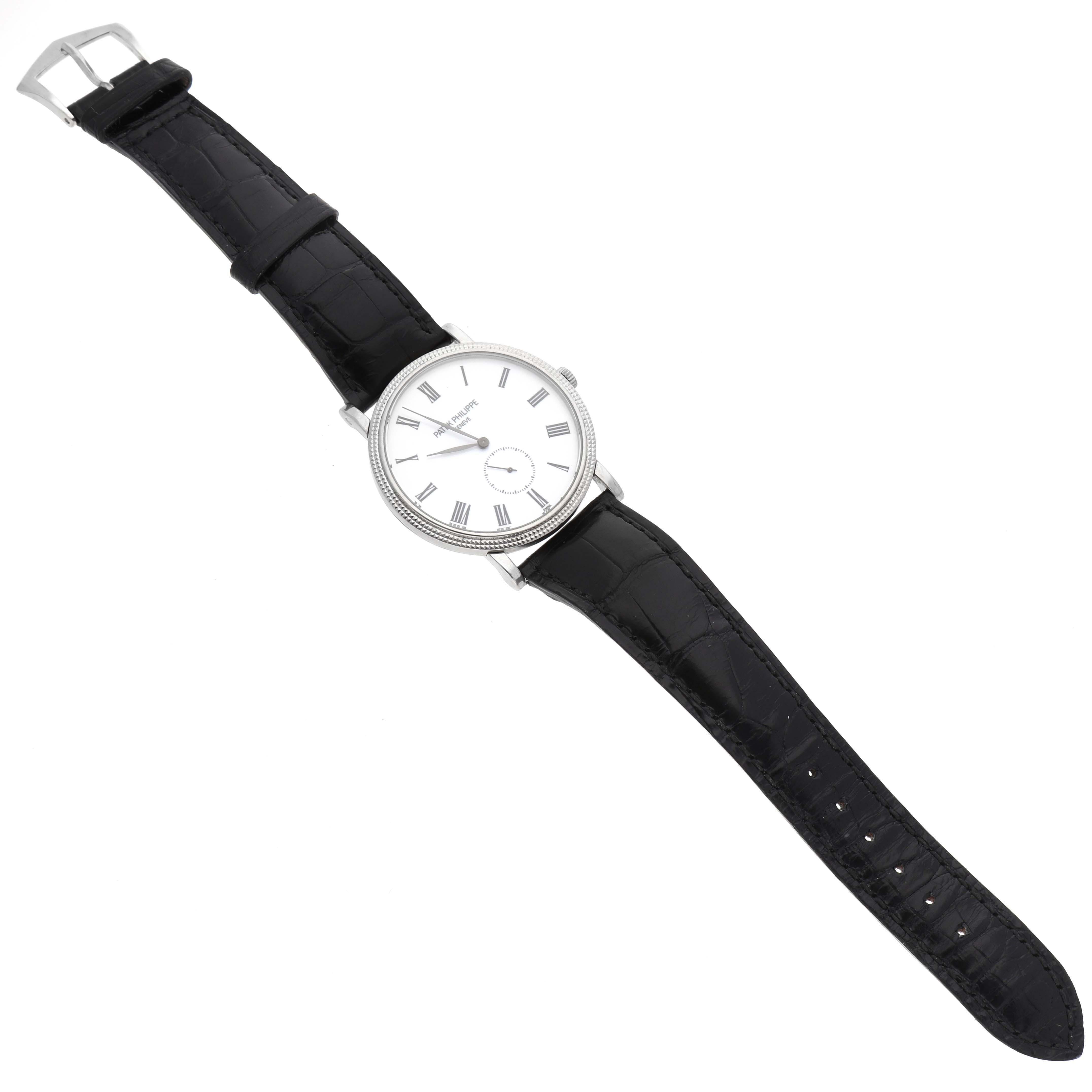 The image shows a Patek Philippe Calatrava 5116G Men
s White Gold White Dial 5116G Men
s White Gold White Dial watch, displaying its full face, black leather strap, and buckle from a top-down angle.