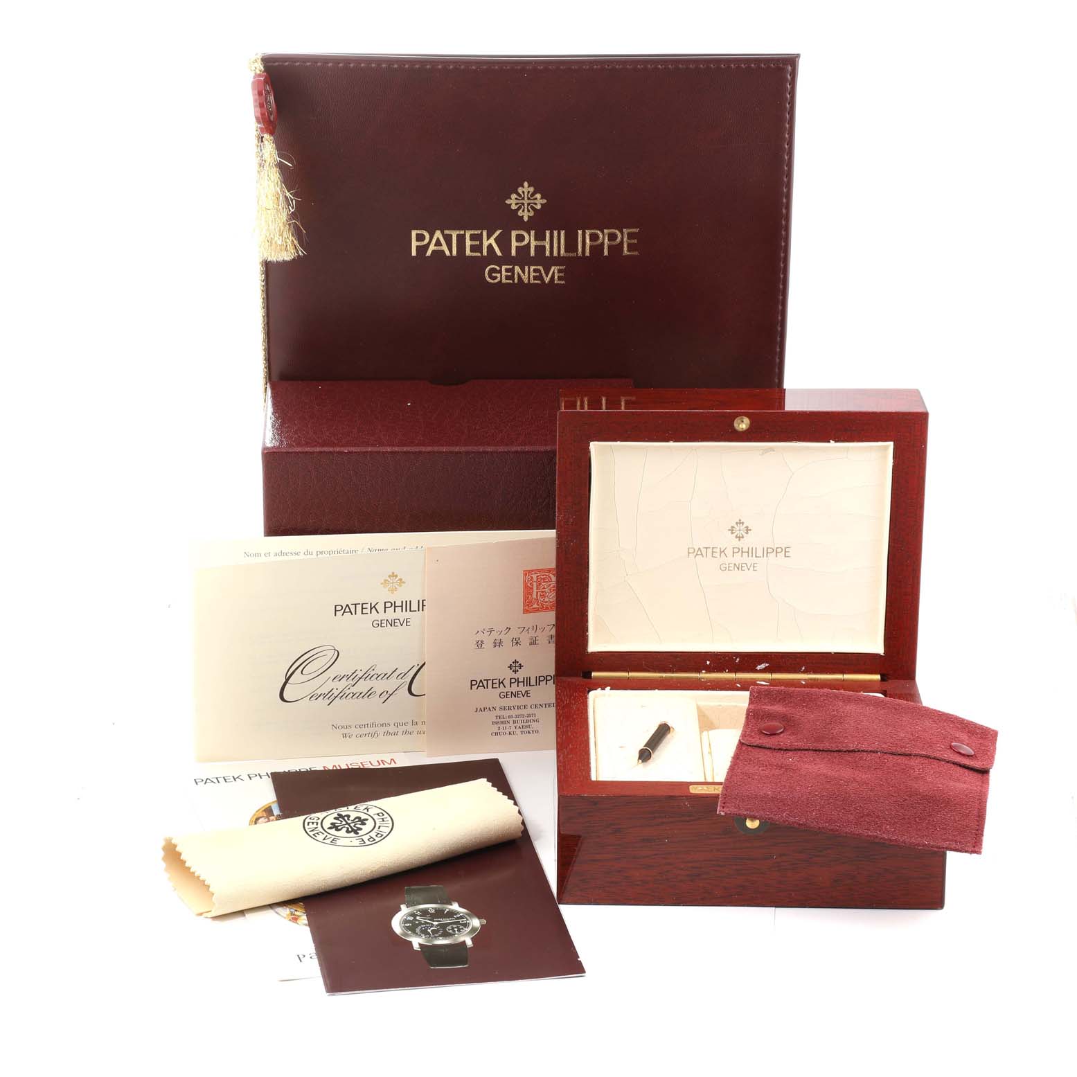 The image shows the box and accessories for the Patek Philippe Complications 5055G-001 Men
s White Gold Black Dial 5055G-001 Men
s White Gold Black Dial watch, including a certificate, manual, and cleaning cloth.