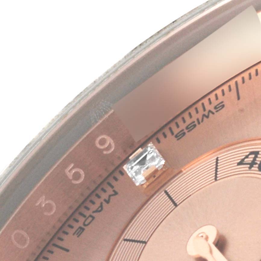 The image shows a close-up of the Rolex Daytona 116505 Men
s Rose Gold Pink Dial 116505 Men
s Rose Gold Pink Dial watch
s dial with hour markers, minute markers, and part of the bezel.
