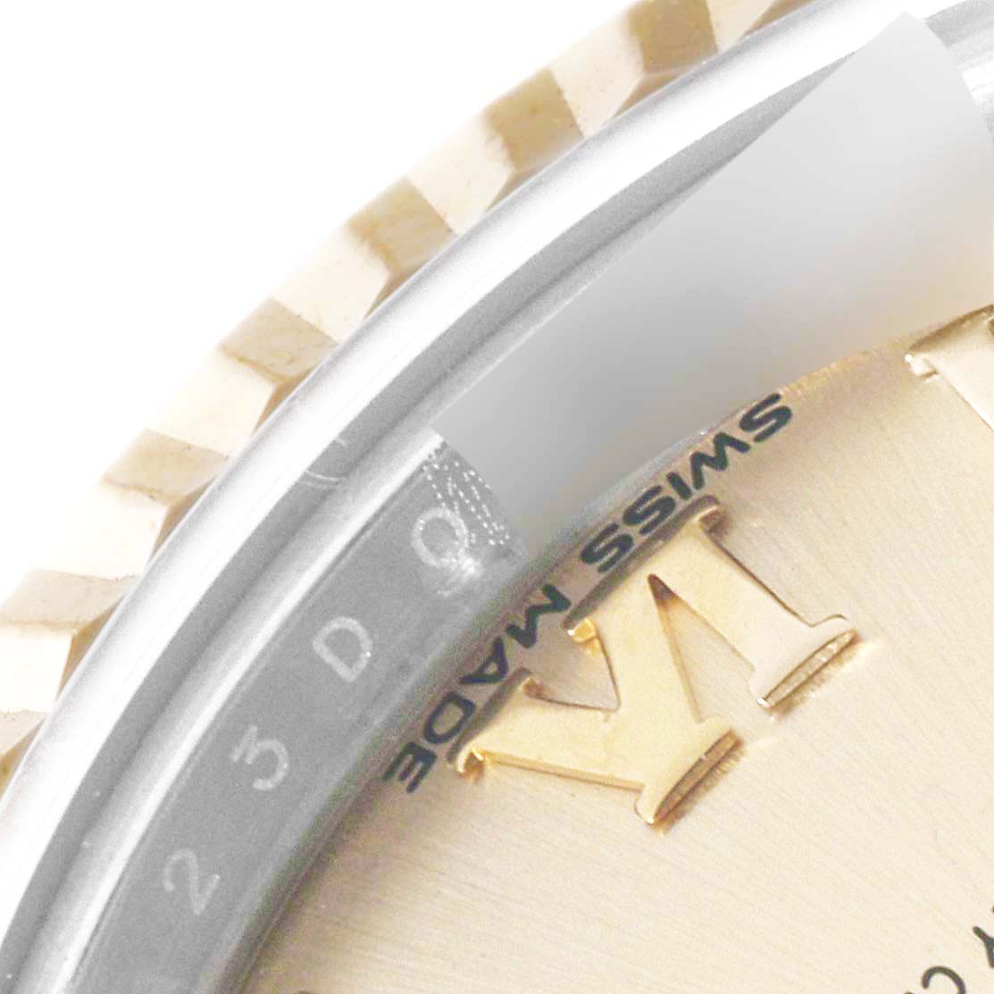 The image shows a close-up of the bezel and partial dial of a Rolex Datejust 279173 Women's Steel and Gold (two tone) Champagne Dial 279173 Women's Steel and Gold (two tone) Champagne Dial watch, revealing the fluted bezel and "SWISS MADE" text.