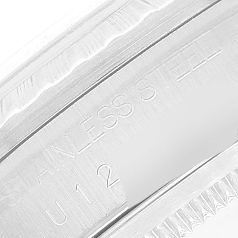 This image shows a macro view of the case back engraving and fluted bezel of a Rolex Datejust 16220 Men's Stainless Steel Blue Dial 16220 Men's Stainless Steel Blue Dial watch.