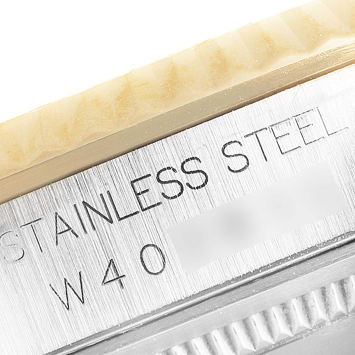 The image shows a close-up of the Rolex Datejust 16233 Men's Steel and Gold (two tone) White Dial 16233 Men's Steel and Gold (two tone) White Dial watch's stainless steel case with etched markings.