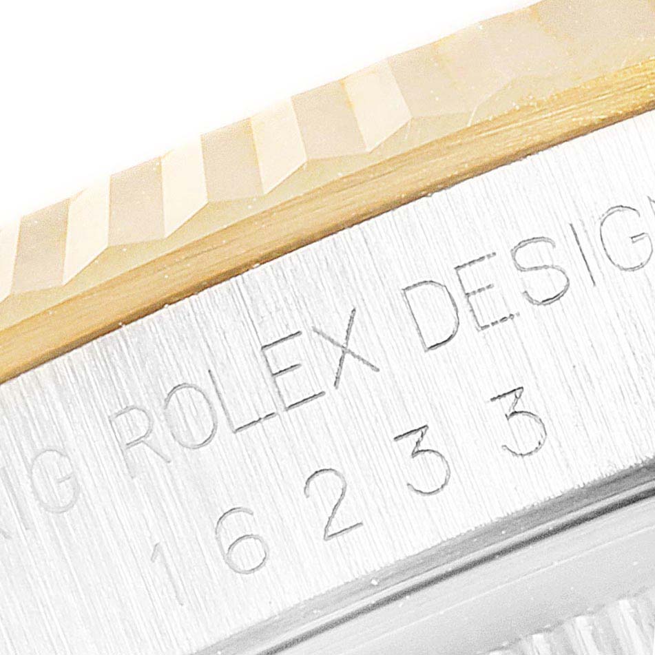 This image shows a close-up of the bezel and engraving details on the side of a Rolex Datejust 16233 Men's Steel and Gold (two tone) White Dial 16233 Men's Steel and Gold (two tone) White Dial watch.