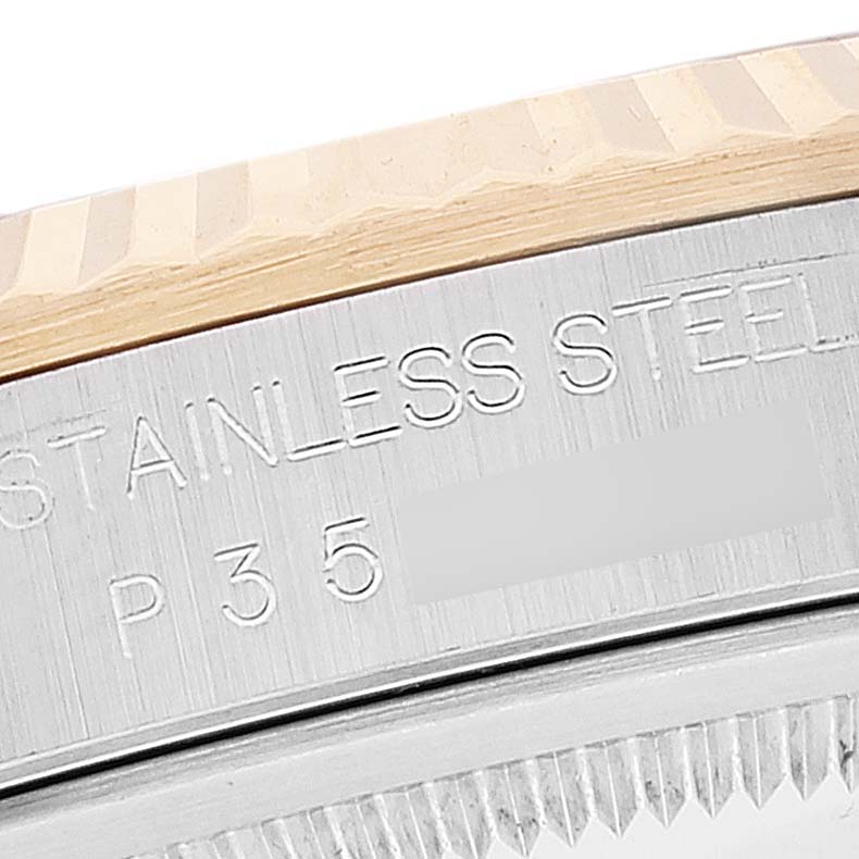 The image shows a close-up of the casing edge of a Rolex Datejust 16233 Men's Steel and Gold (two tone) White Dial 16233 Men's Steel and Gold (two tone) White Dial watch, revealing the engraved text "STAINLESS STEEL" and partial serial number.