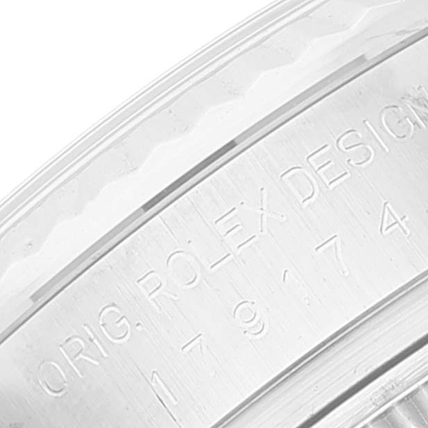 The image shows the side view of a Rolex Datejust 179174 Women's Stainless Steel Black Dial 179174 Women's Stainless Steel Black Dial's engraved case with visible text and serial numbers.