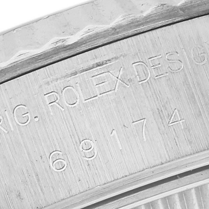This image shows an engraved section of the bezel and casing of a Rolex Datejust 69174 Women's Stainless Steel Pink Dial 69174 Women's Stainless Steel Pink Dial watch.