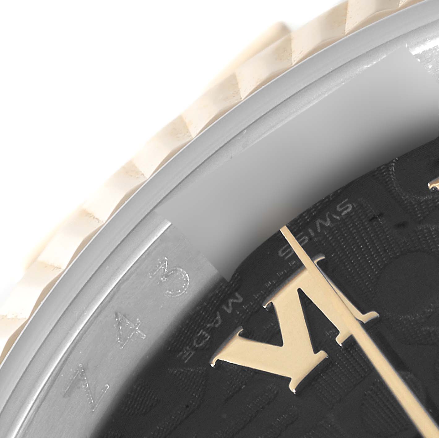 This close-up image of a Rolex Datejust 116233 Men's Steel and Gold (two tone) Black Dial 116233 Men's Steel and Gold (two tone) Black Dial watch shows a portion of the dial, bezel, and engraved details on the inner case.