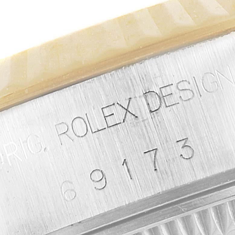 This close-up of the Rolex Datejust 69173 Women's Steel and Gold (two tone) Grey Dial 69173 Women's Steel and Gold (two tone) Grey Dial watch shows the model's serial number and part of the bezel.