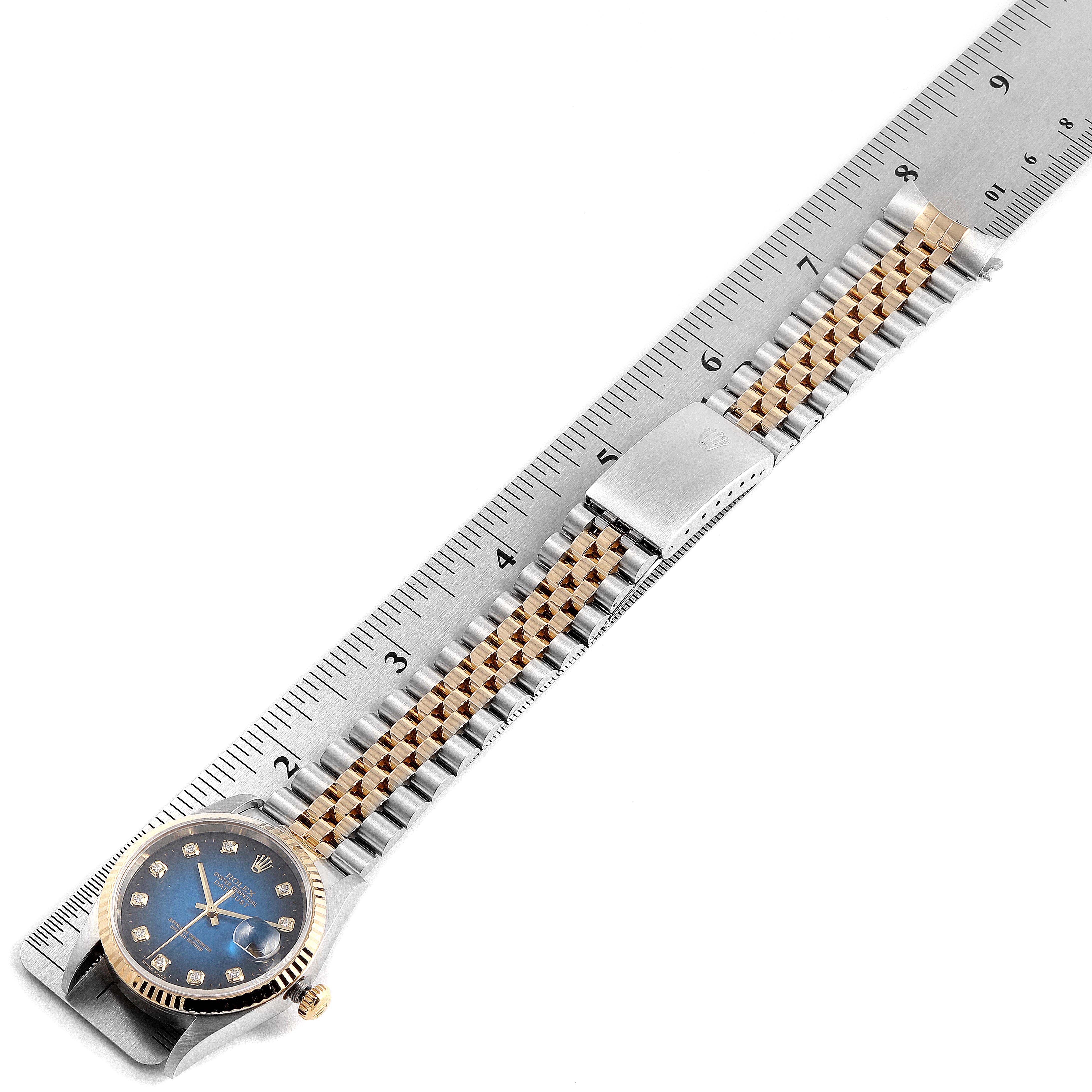 This image shows a Rolex Datejust 16233 Men's Steel and Gold (two tone) Blue Dial 16233 Men's Steel and Gold (two tone) Blue Dial watch with a blue dial and diamond markers, displayed alongside a ruler for size reference.