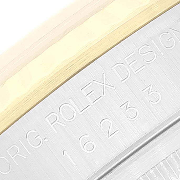 This image shows a close-up of the side of a Rolex Datejust 16233 Men's Steel and Gold (two tone) Champagne Dial 16233 Men's Steel and Gold (two tone) Champagne Dial, featuring engraved text and part of the bezel.