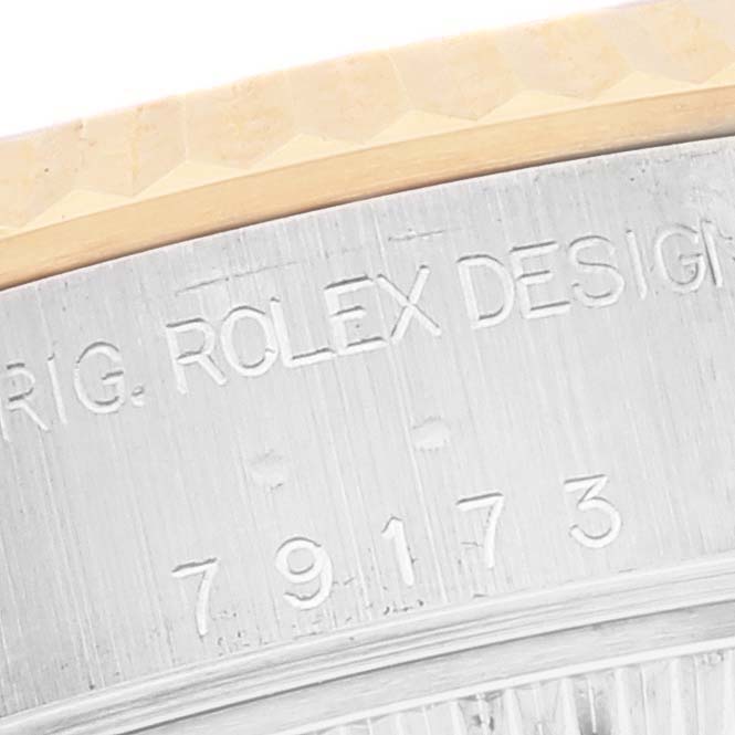 This image shows a close-up angle of the rim of a Rolex Datejust 79173 Women's Steel and Gold (two tone) White Dial 79173 Women's Steel and Gold (two tone) White Dial watch, highlighting its engraved details.