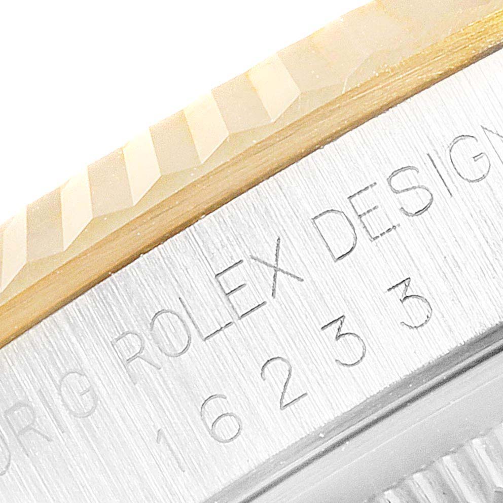 This close-up image of the Rolex Datejust 16233 Men's Steel and Gold (two tone) White Dial 16233 Men's Steel and Gold (two tone) White Dial watch shows the fluted bezel and engraved case details.