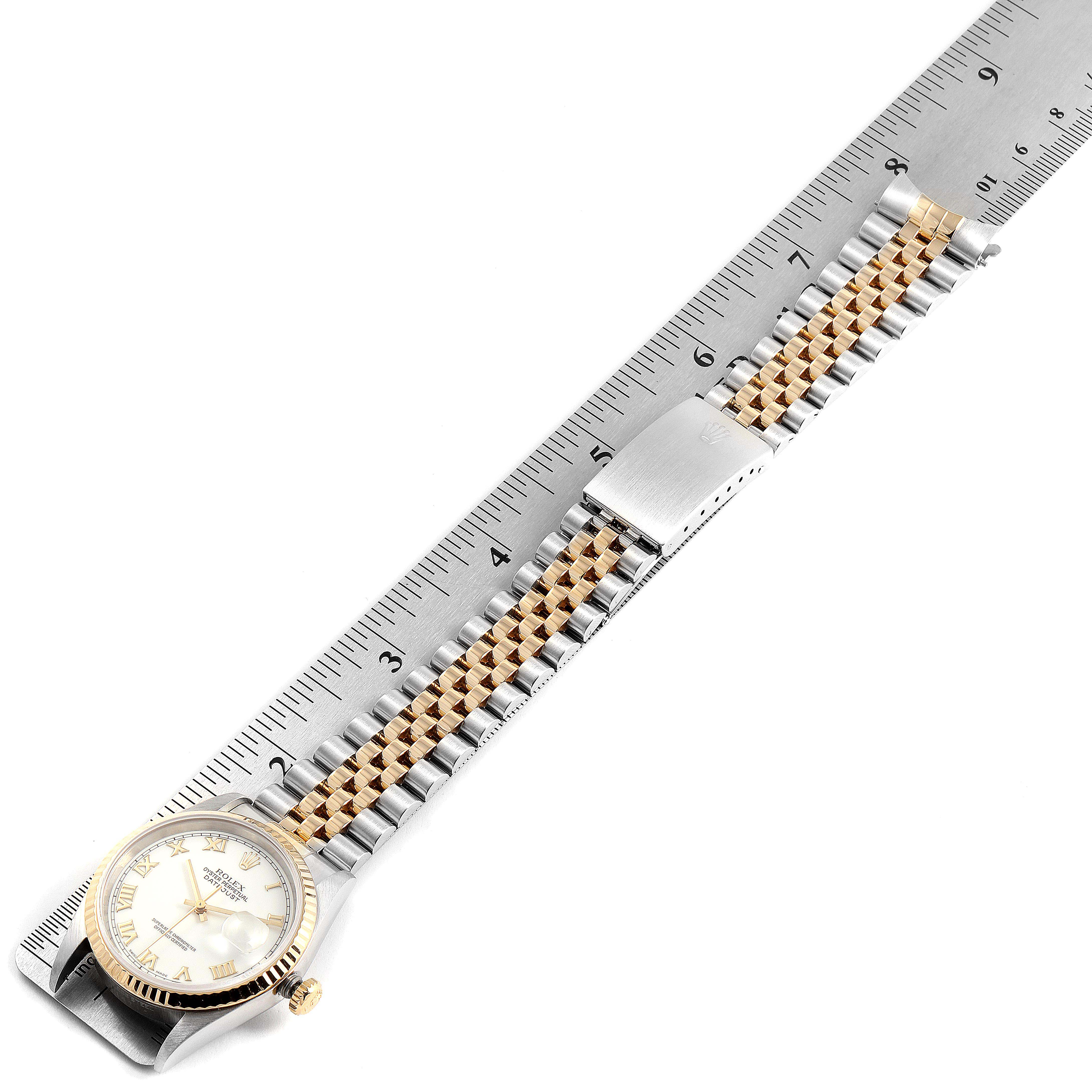 This image shows the Rolex Datejust 16233 Men's Steel and Gold (two tone) White Dial 16233 Men's Steel and Gold (two tone) White Dial watch laid flat, displaying the face, band, and clasp with a ruler for measurement.