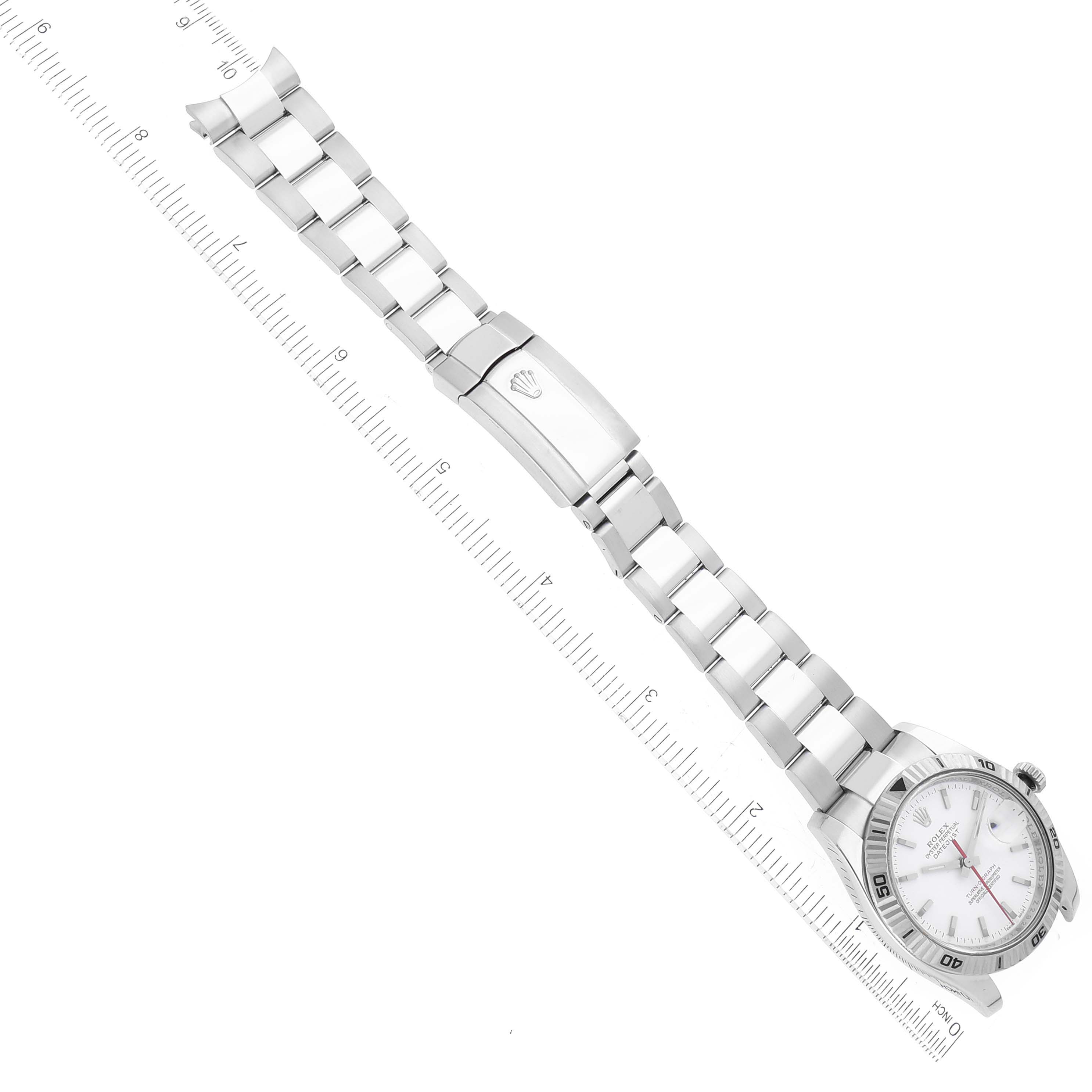 The Rolex Turn-o-Graph 116264 Men
s Stainless Steel White Dial 116264 Men
s Stainless Steel White Dial watch is shown from a top-down angle with its full bracelet and clasp visible next to a measuring ruler.