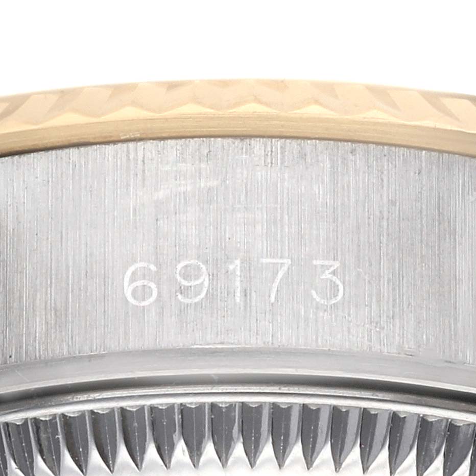 The image shows a macro view of the serial number and fluted bezel of a Rolex Datejust 69173 Women's Steel and Gold (two tone) Blue Dial 69173 Women's Steel and Gold (two tone) Blue Dial model.