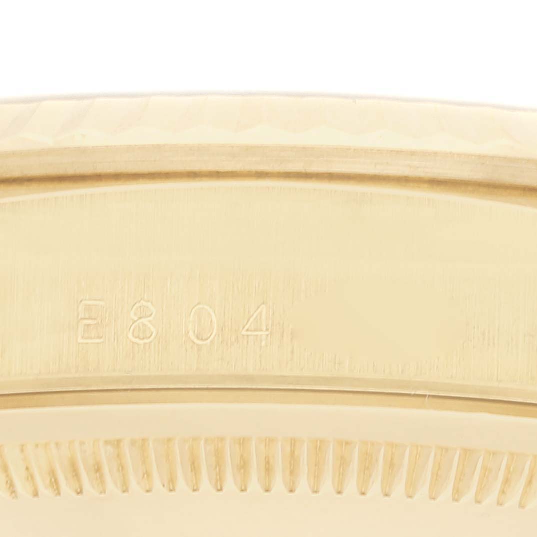 This image shows a close-up of the side view of a Rolex President 18238 Men
s Yellow Gold Champagne Dial 18238 Men
s Yellow Gold Champagne Dial watch case, highlighting its serial number "E804."
