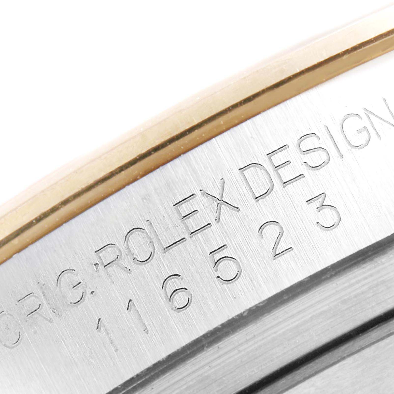This close-up image shows the engraved serial number and "Rolex Design" on the side case of the Rolex Daytona 116523 Men's Steel and Gold (two tone) Champagne Dial 116523 Men's Steel and Gold (two tone) Champagne Dial watch.