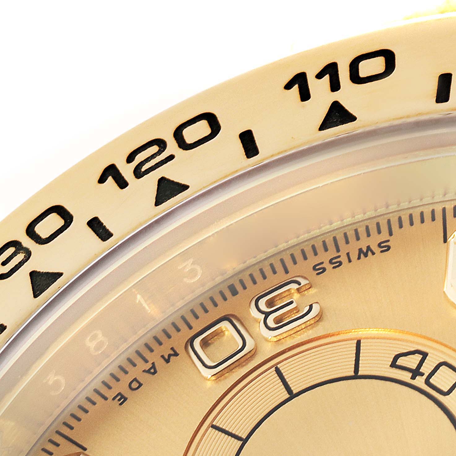 This close-up image shows the bezel and a portion of the dial of a Rolex Daytona 116508 Men's Yellow Gold Champagne Dial 116508 Men's Yellow Gold Champagne Dial watch.