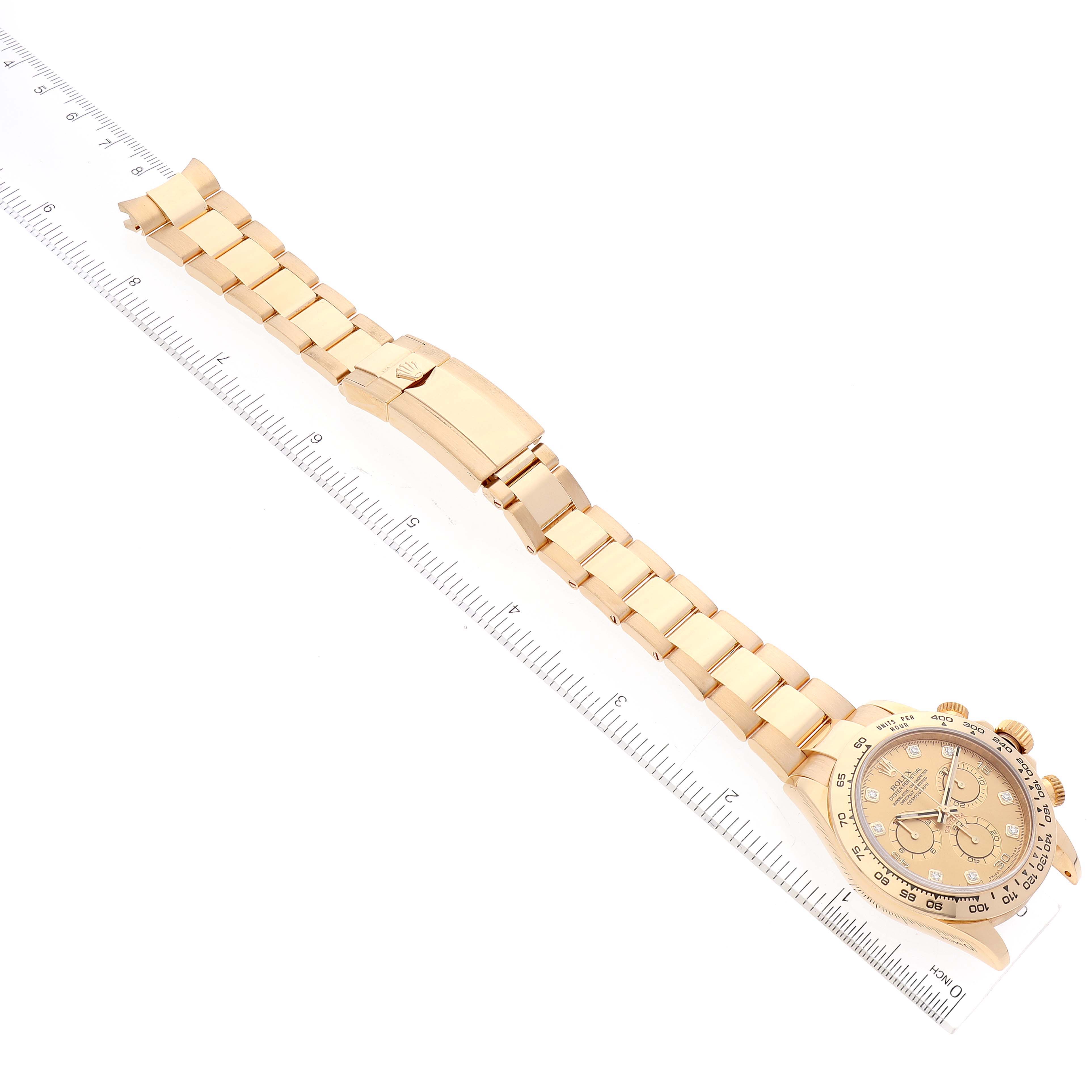 The image shows a Rolex Daytona 116508 Men's Yellow Gold Champagne Dial 116508 Men's Yellow Gold Champagne Dial watch laid flat alongside a ruler, displaying its bracelet, clasp, and dial from an overhead angle.