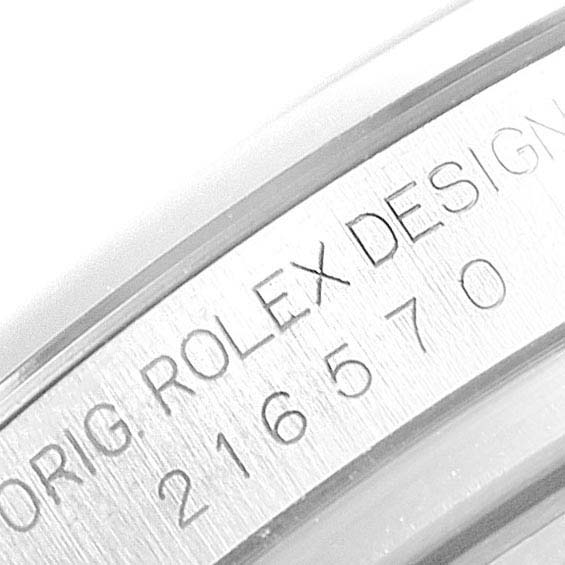 The image shows a close-up of the Rolex Explorer 216570 Men's Stainless Steel Black Dial 216570 Men's Stainless Steel Black Dial case with the engraving "ROLEX DESIGN" and the model number "216570."