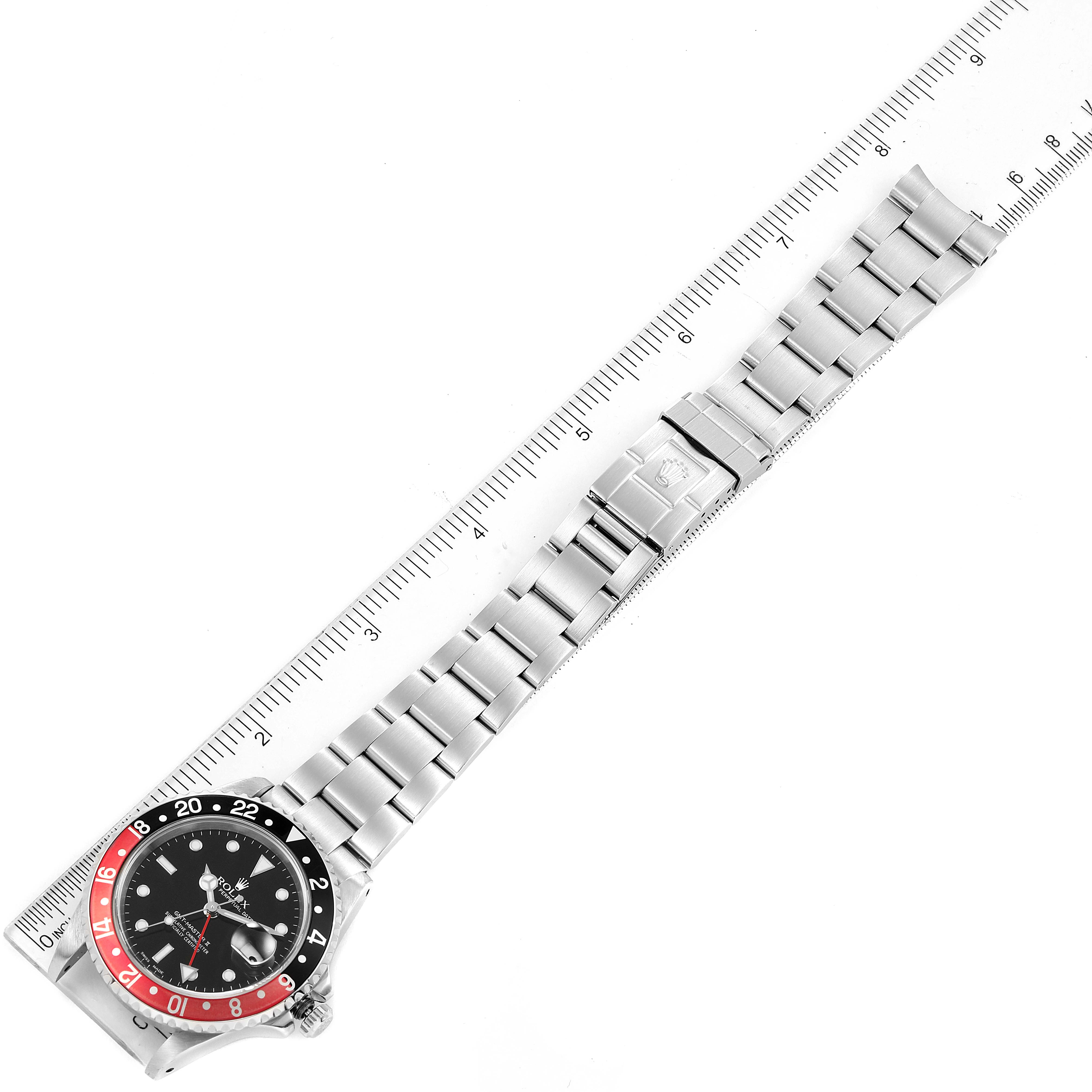 The image shows an aerial view of a Rolex GMT-Master 16710 Men
s Stainless Steel Black Dial 16710 Men
s Stainless Steel Black Dial watch, highlighting the entire bracelet and bezel with a ruler for scale.