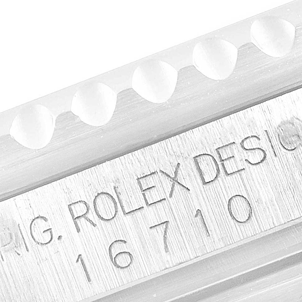 This image shows a close-up of the engraved serial number and part of the bezel teeth on a Rolex GMT-Master 16710 Men
s Stainless Steel Black Dial 16710 Men
s Stainless Steel Black Dial watch.